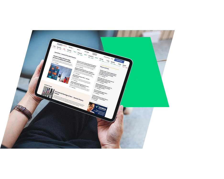 Over-the-shoulder view of a person holding a tablet displaying the MarketPulse financial news website, featuring market charts and recent articles.